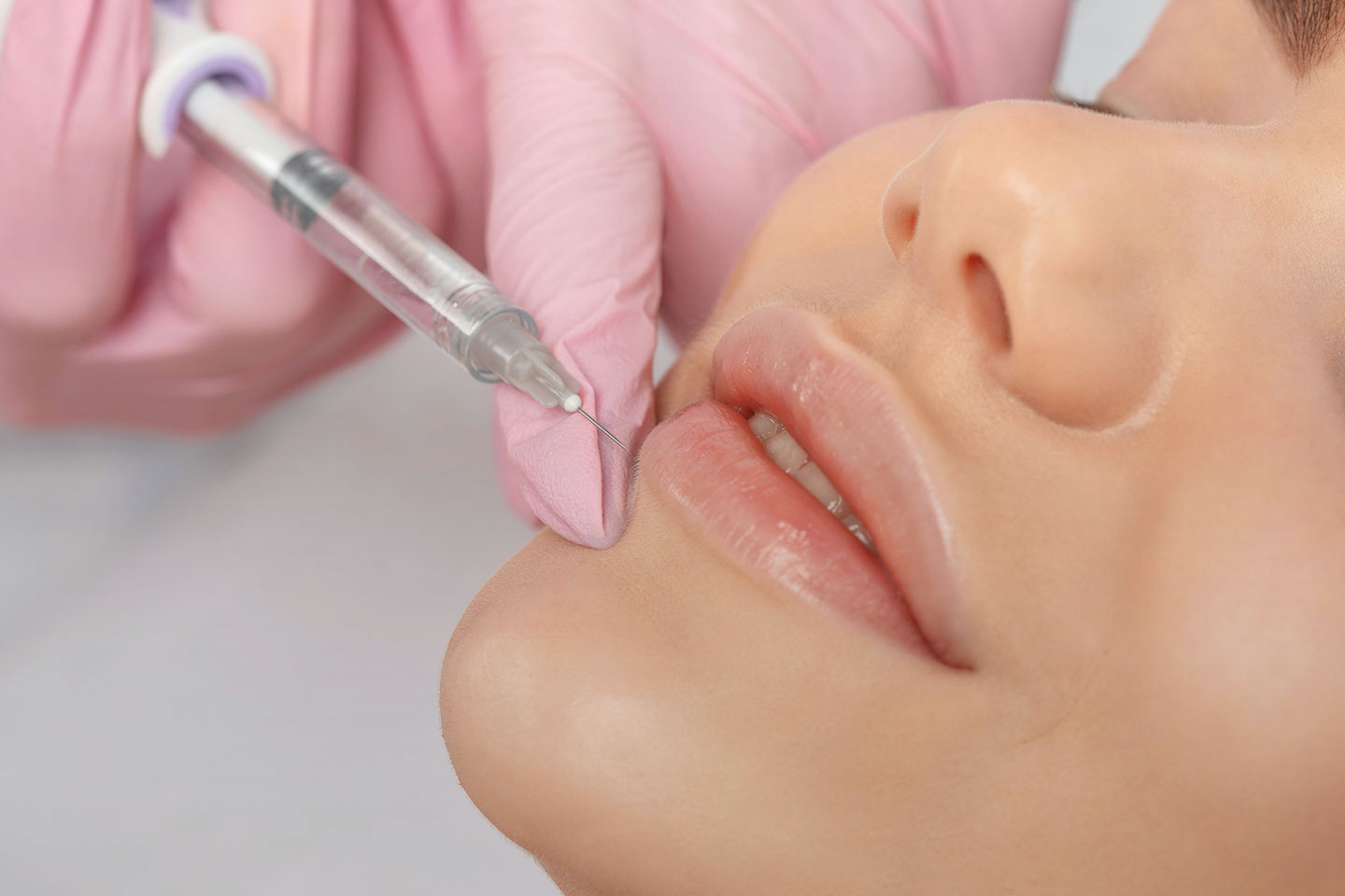 A woman getting a lip injection in a clinic.