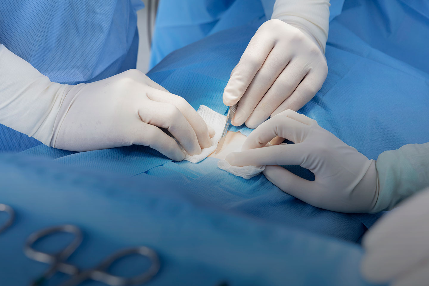 A pair of surgeons working on a patient in an operating room.