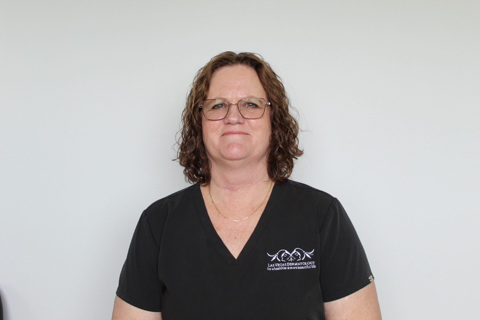 Woman wearing glasses and a black shirt.