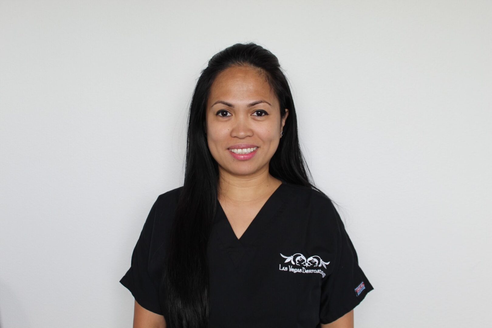 Smiling woman in black scrubs.