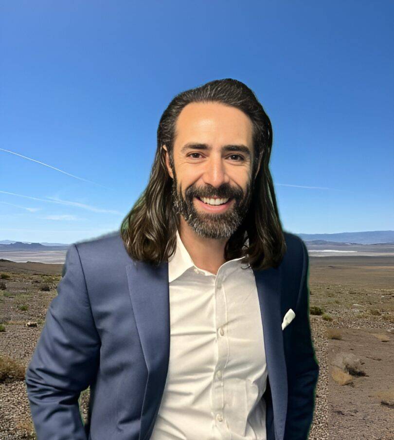Smiling man in suit, desert background.