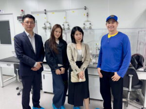 Four people in lab wearing blue shoe covers