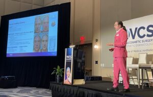 Man in pink suit presenting at medical conference